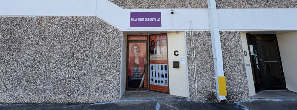 Building exterior with a door and sign, featuring a textured wall and clear sky.