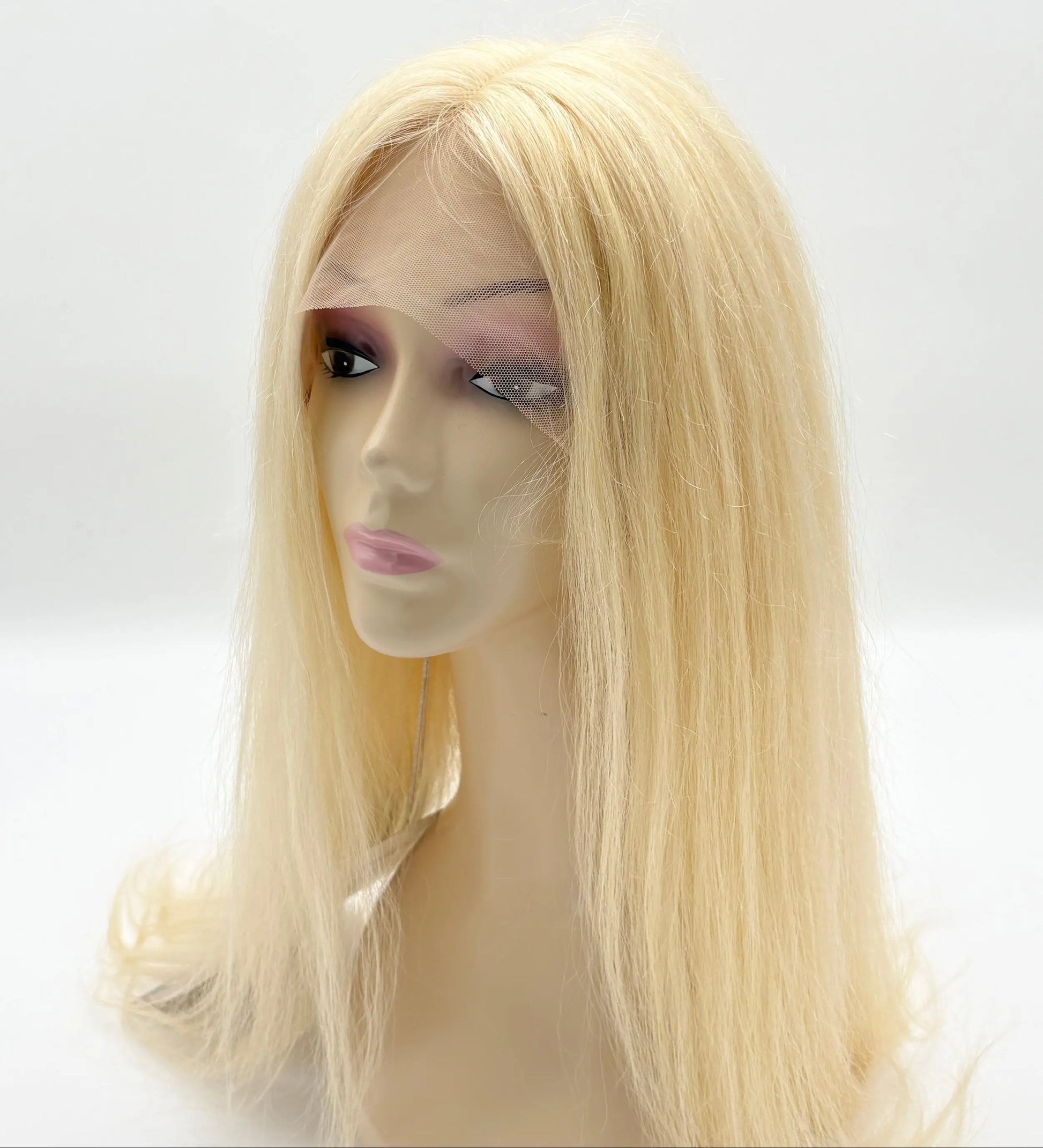 Blonde wig on a mannequin head against a white background