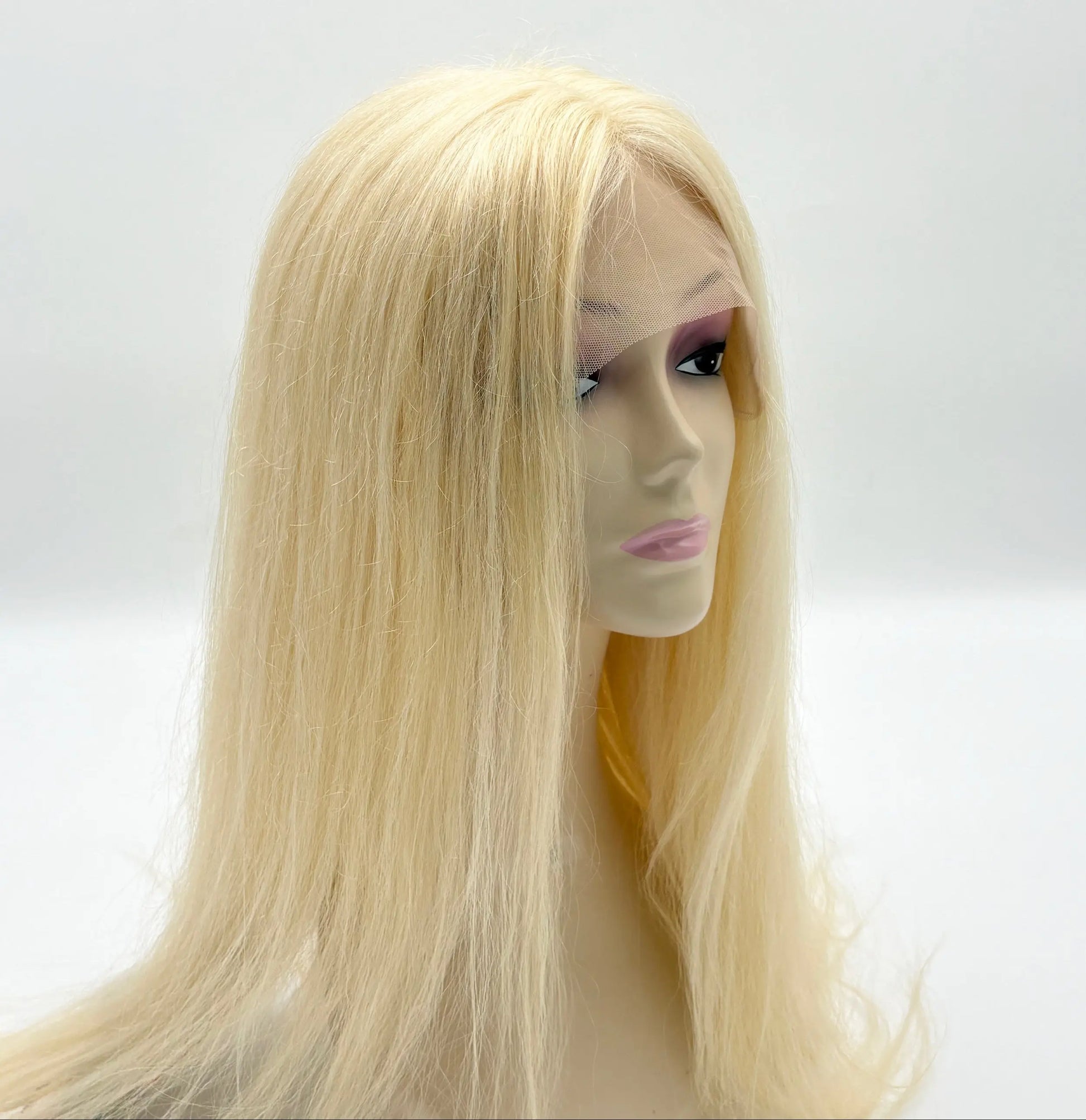 Blonde wig on a mannequin head against a white background