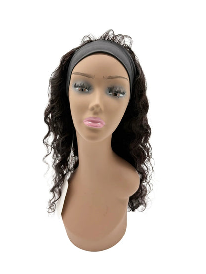 Mannequin head with a black wavy hairpiece on a white background