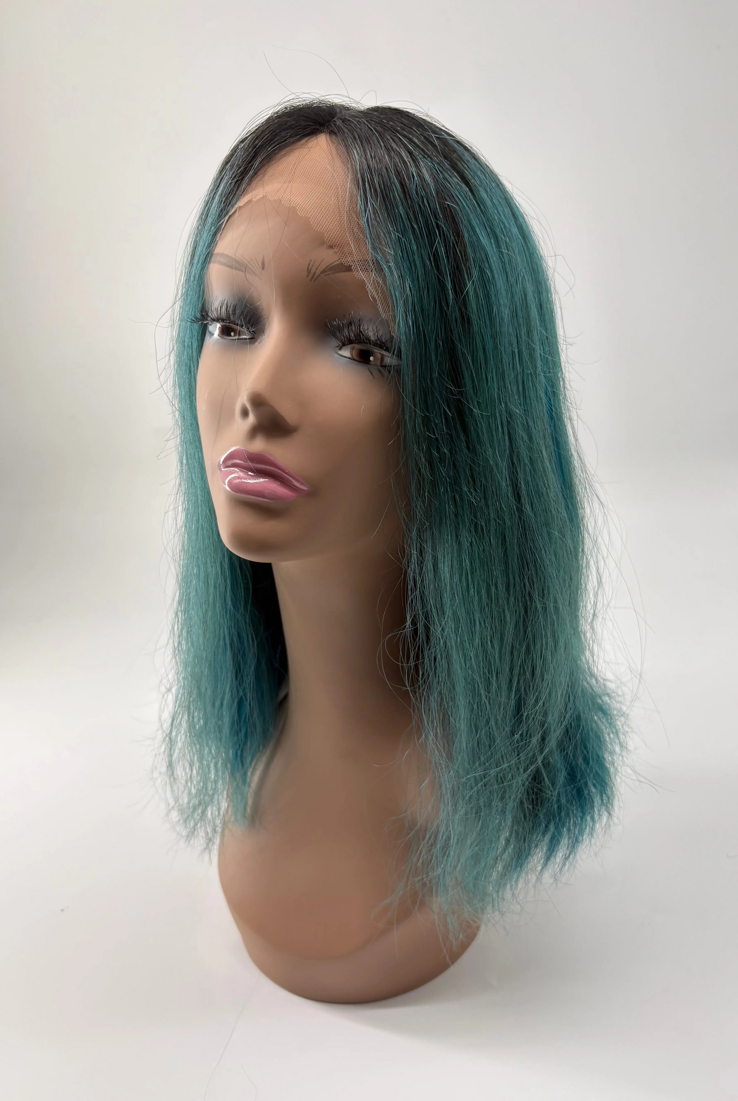 Mannequin head with a teal wig on a white background