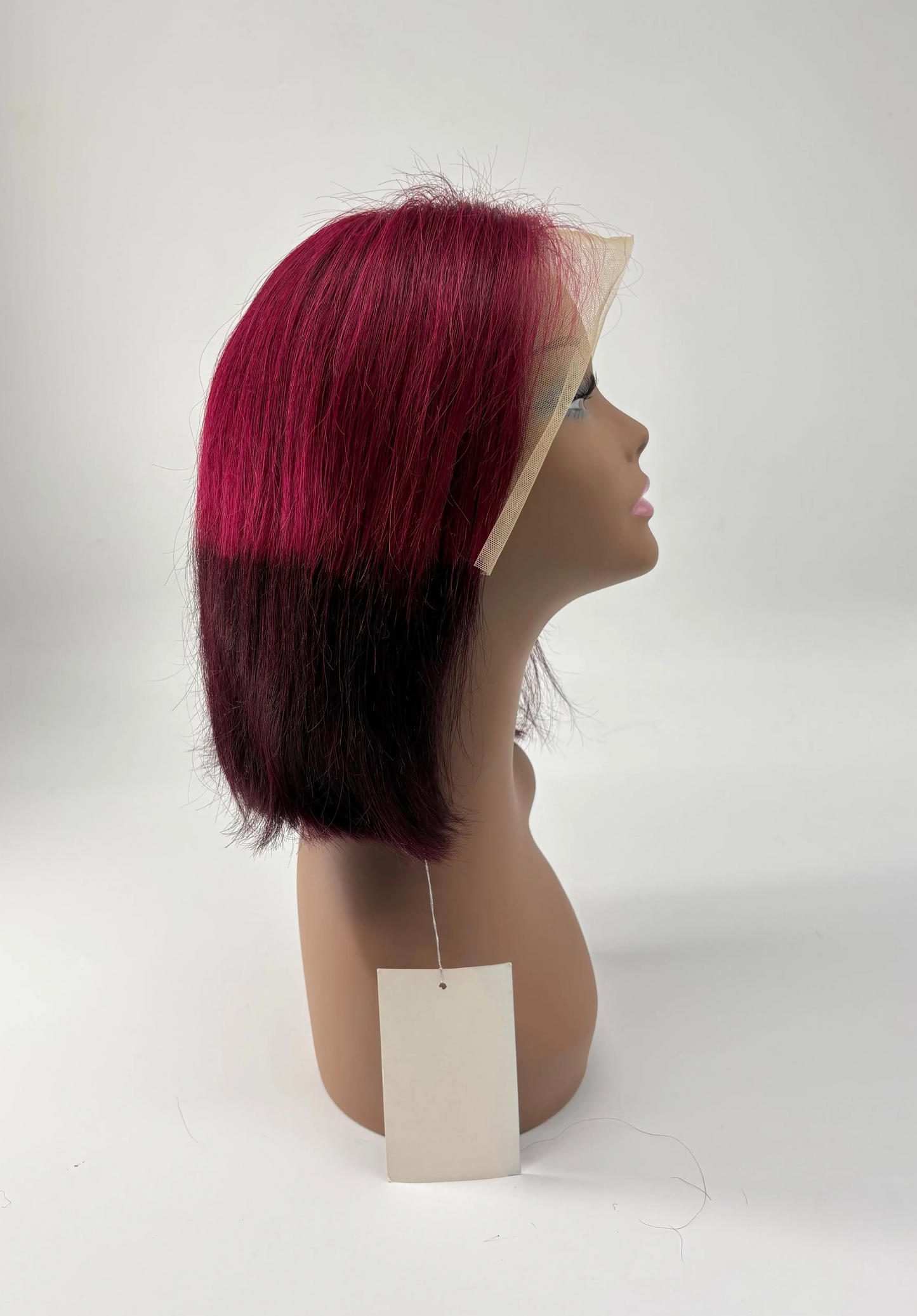 Mannequin head with a red and black ombre wig on a white background