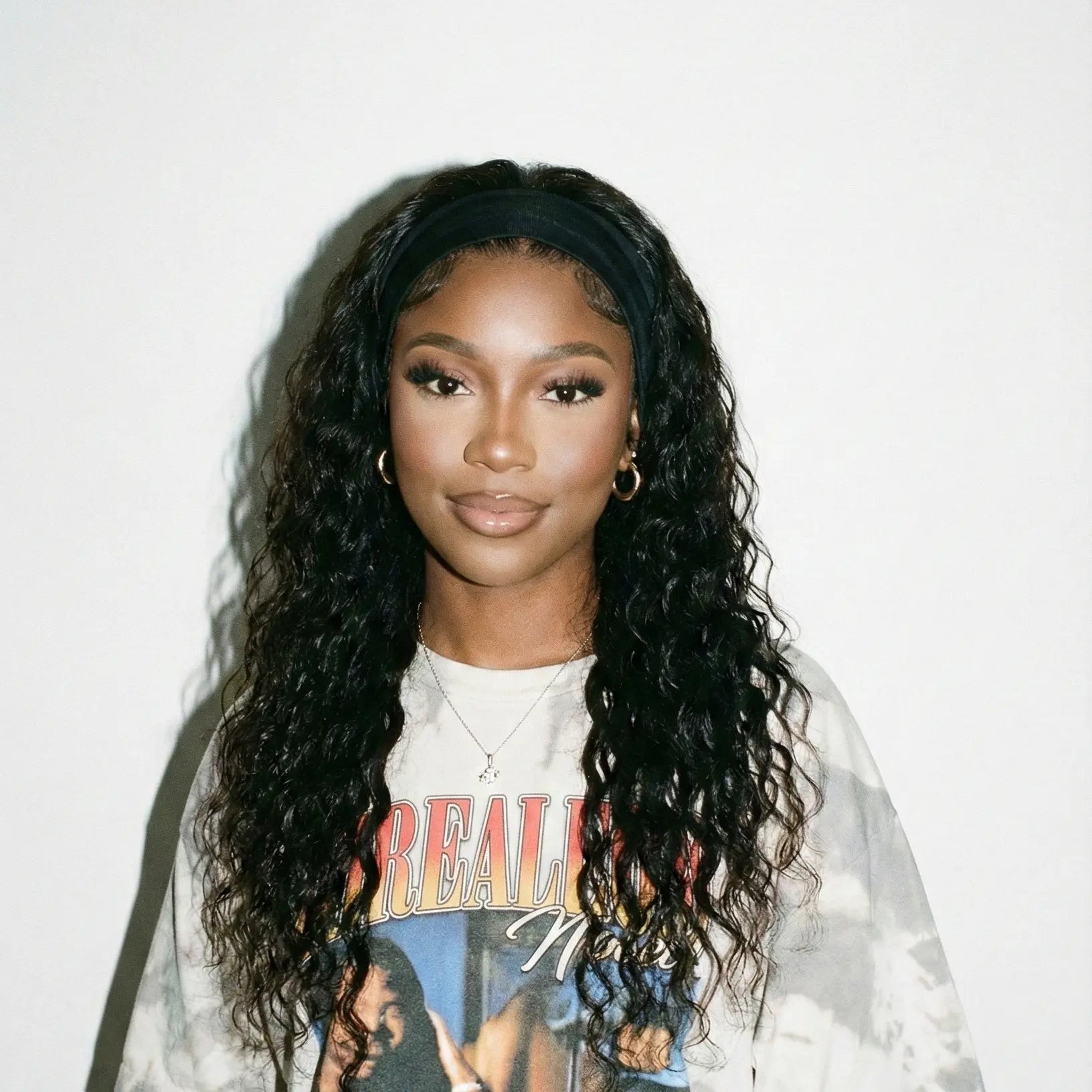 Person wearing a graphic t-shirt with a colorful design on a plain background