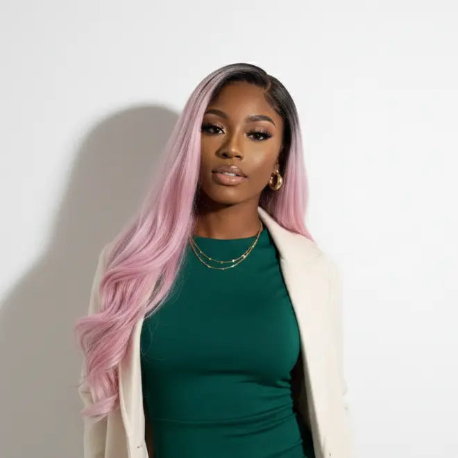 Woman wearing a green dress and cream coat with pink hair against a white background