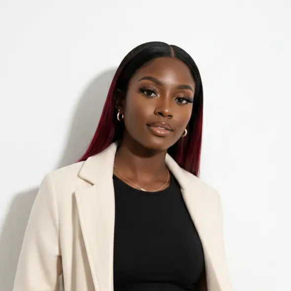 Woman wearing a beige coat over a black dress against a white background
